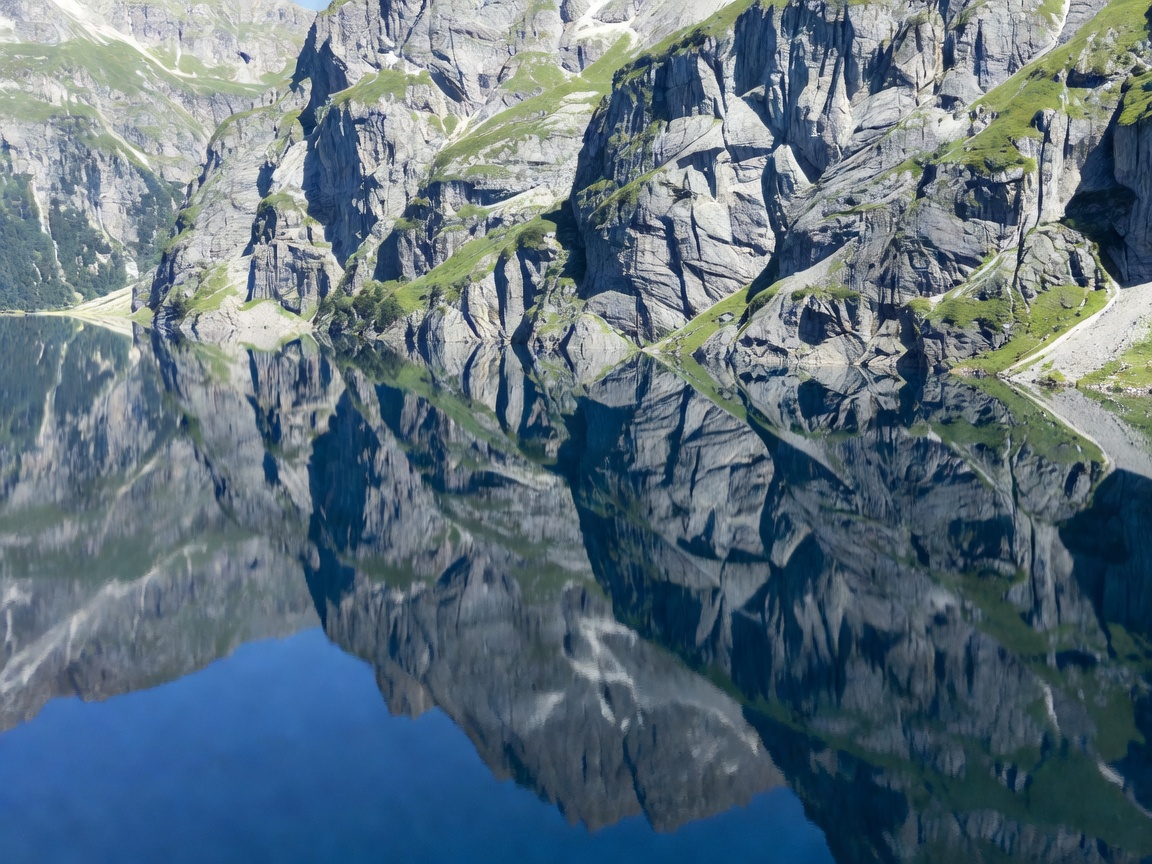 High angle view of Oeschinensee lake reflecting the sheer cliff faces